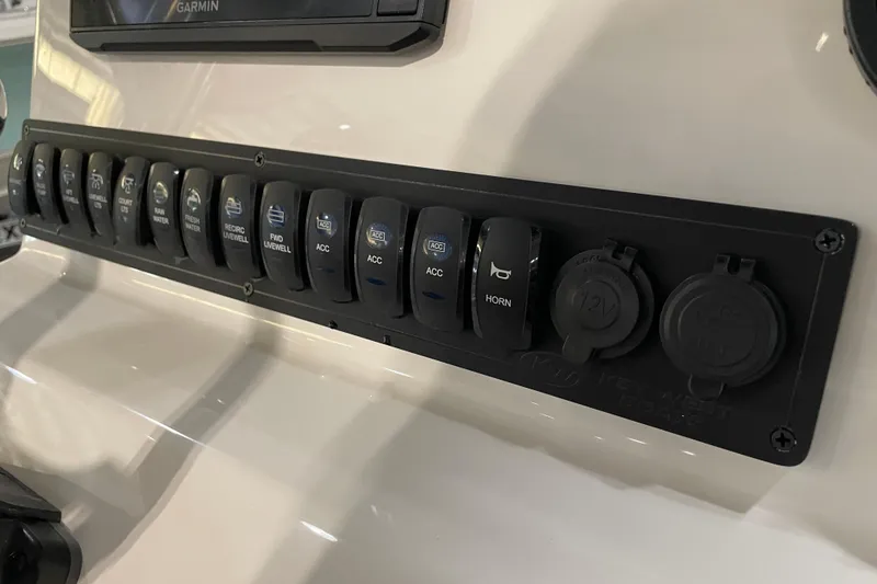 Slide: The Image of Control panel of 2026 Key West 210 Bay Reef boat with labeled switches and outlets. - 34