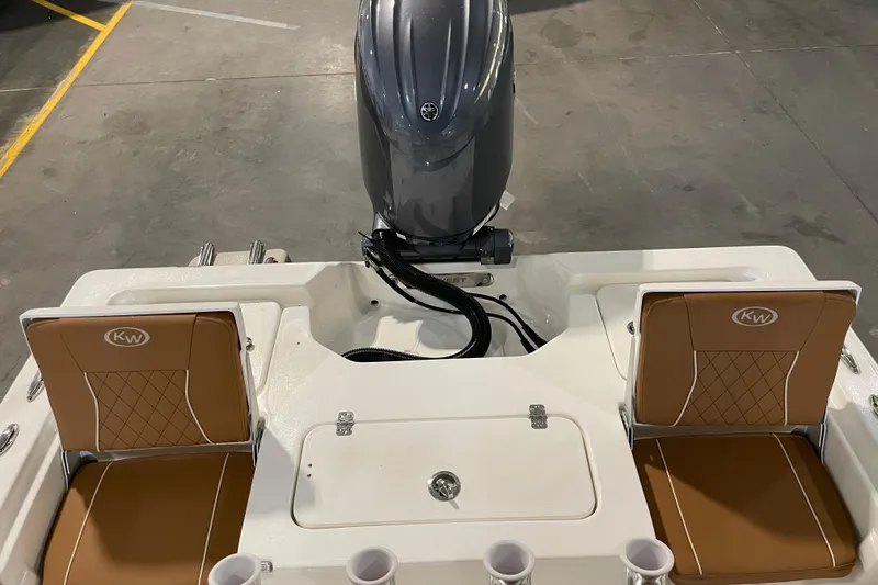 Slide: The Image of 2026 Key West 210 Bay Reef boat with brown seats and outboard motor in a garage. - 40