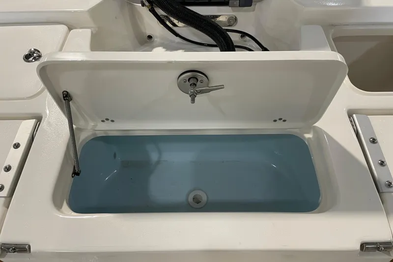 Slide: The Image of 2026 Key West 210 Bay Reef boat livewell with open lid and blue interior. - 41