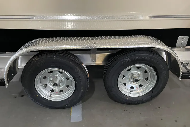 Slide: The Image of 2026 Key West 210 Bay Reef trailer wheels with diamond plate fender in garage setting. - 47