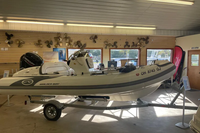 Slide: The Image of 2022 Walker Bay Venture 16 boat displayed indoors on a trailer. - 0
