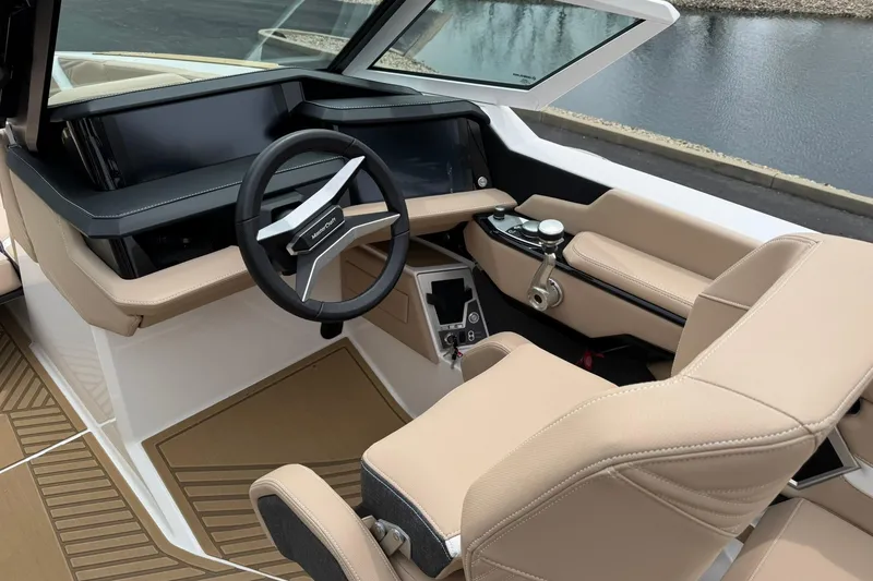 Slide: The Image of 2025 MasterCraft XStar 23 boat interior with modern steering and beige seating. - 10