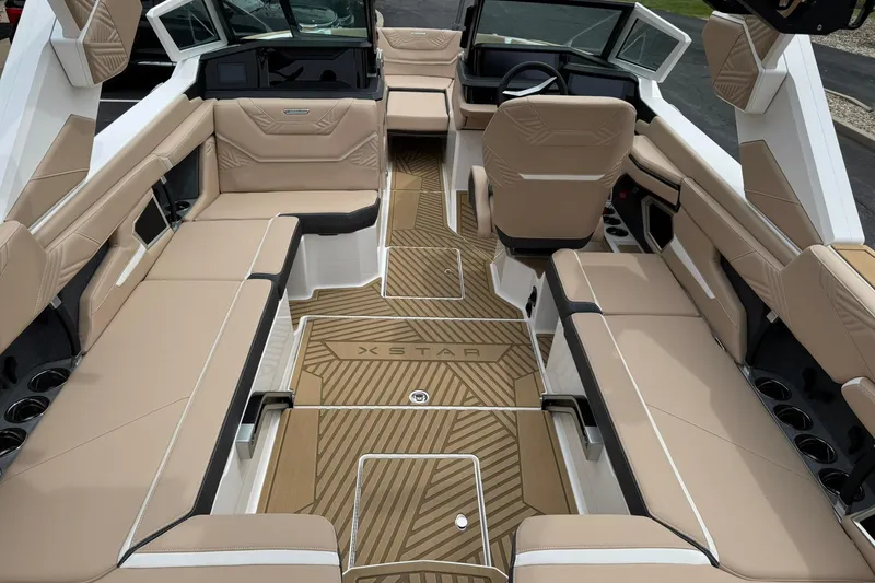 Slide: The Image of 2025 MasterCraft XStar 23 boat interior with beige seating and modern design. - 14