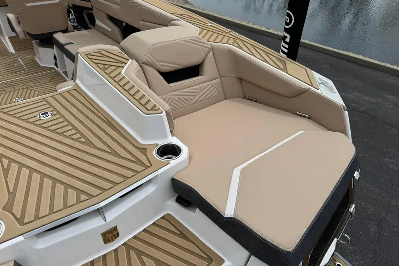 Slide: The Image of 2025 MasterCraft XStar 23 boat interior with tan seating and wood-patterned flooring. - 17