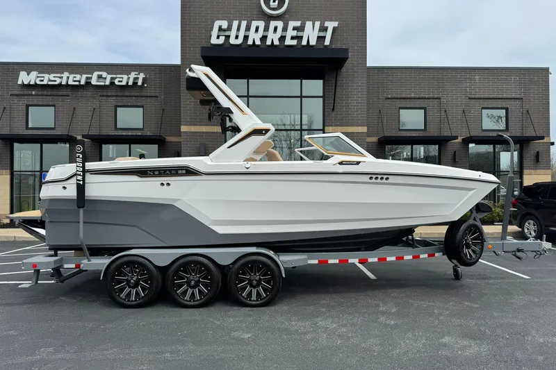 Slide: The Image of 2025 MasterCraft XStar 23 boat on trailer outside dealership. - 3