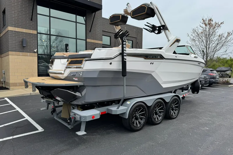 Slide: The Image of 2025 MasterCraft XStar 23 boat on a trailer in a parking lot. - 4