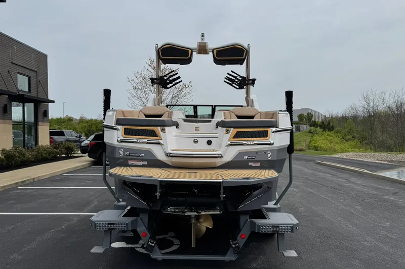 Slide: The Image of 2025 MasterCraft XStar 23 boat, rear view in parking lot, showcasing sleek design and features. - 5