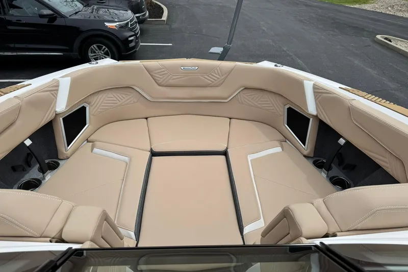 Slide: The Image of 2025 MasterCraft XStar 23 boat interior with beige seating and cup holders. - 9