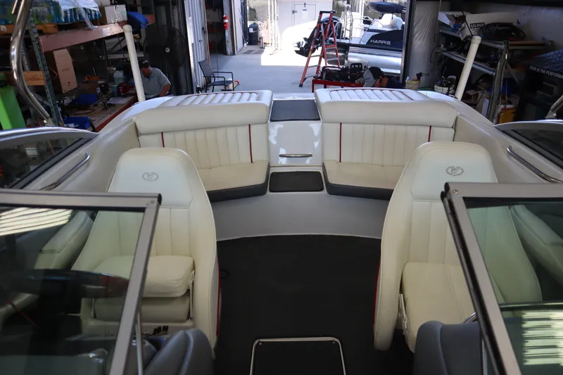 Slide: The Image of 2006 Cobalt 220 boat interior with white leather seating in a garage setting. - 10