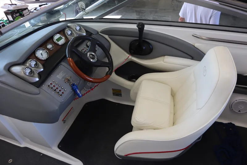 Slide: The Image of Interior of a 2006 Cobalt 220 boat featuring a sleek dashboard and white captain's chair. - 13