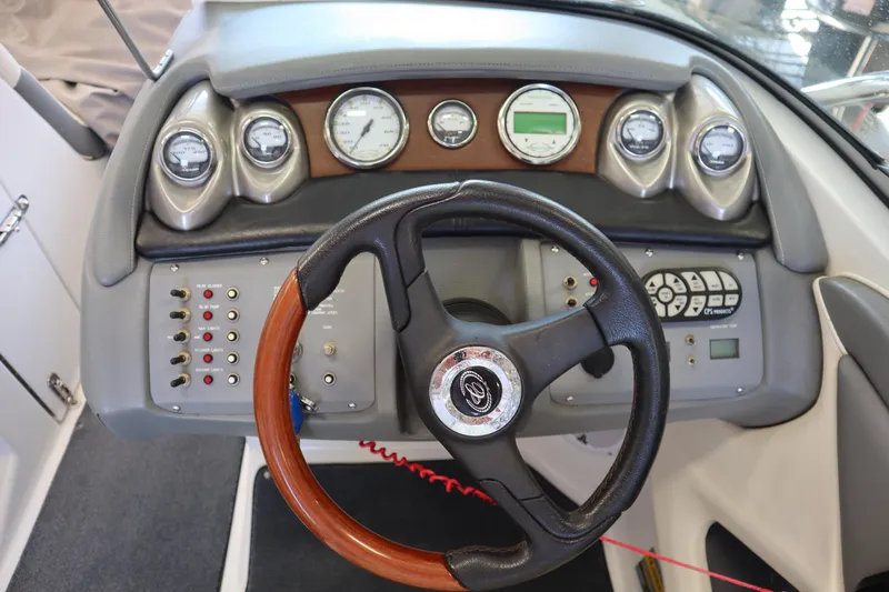 Slide: The Image of Dashboard of a 2006 Cobalt 220 boat with steering wheel and gauges. - 14