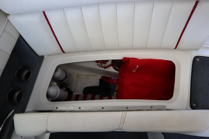 Slide: The Image of Storage compartment in a 2006 Cobalt 220 boat with red bag and fire extinguishers. - 19