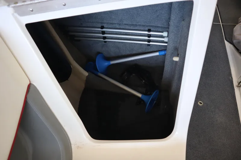 Slide: The Image of Storage compartment in a 2006 Cobalt 220 boat with blue paddles and equipment. - 8