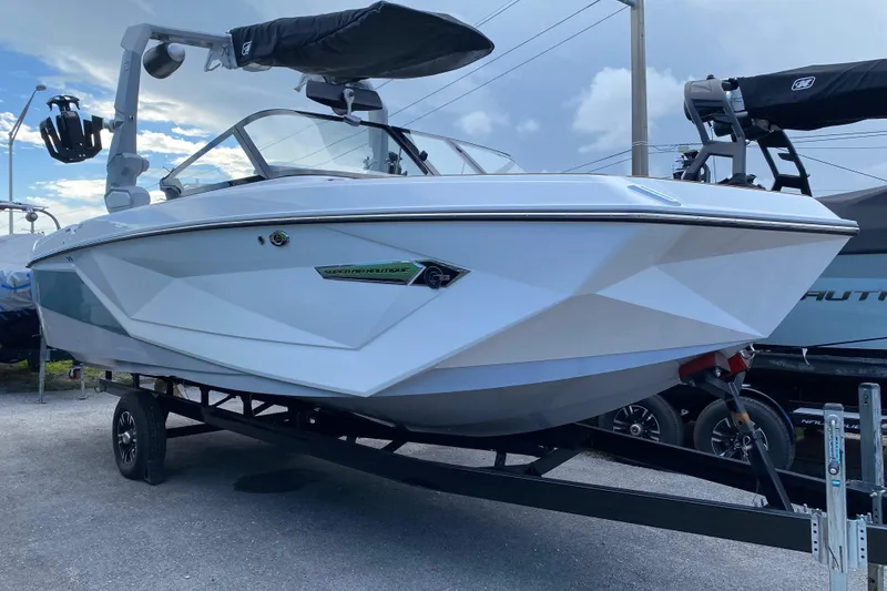 The Image of 2022 Nautique Super Air Nautique G23 Coastal Edition boat on trailer, side view. - 1