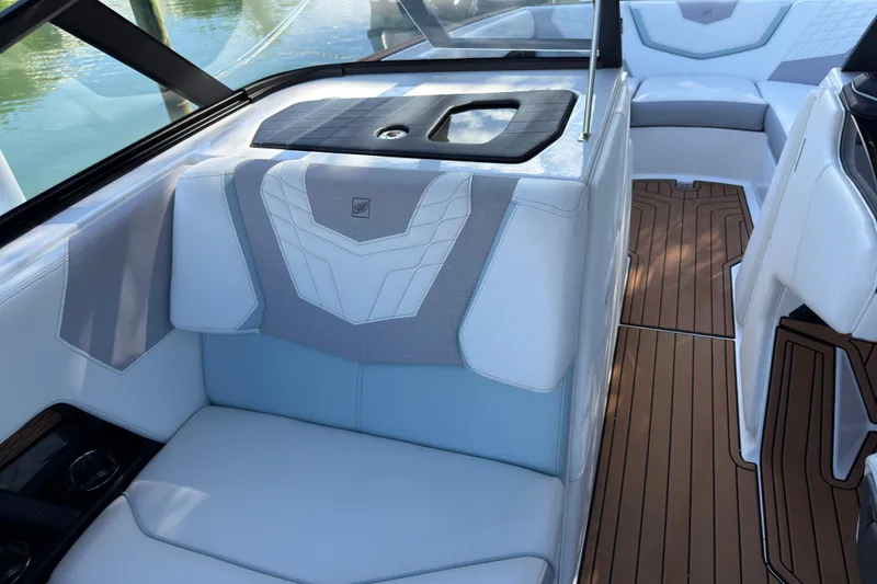 Slide: The Image of 2022 Nautique Super Air Nautique G23 Coastal Edition interior with luxurious seating and teak flooring. - 16