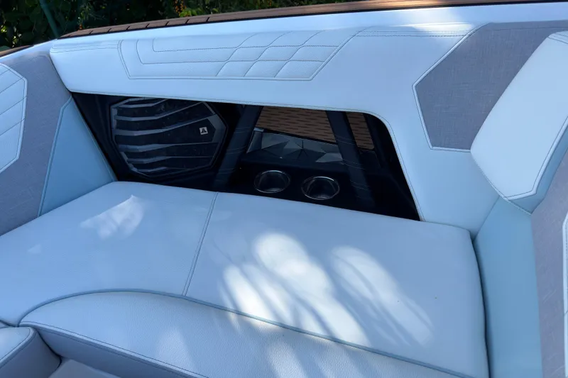Slide: The Image of 2022 Nautique Super Air Nautique G23 Coastal Edition interior seating with speaker and cup holders. - 8