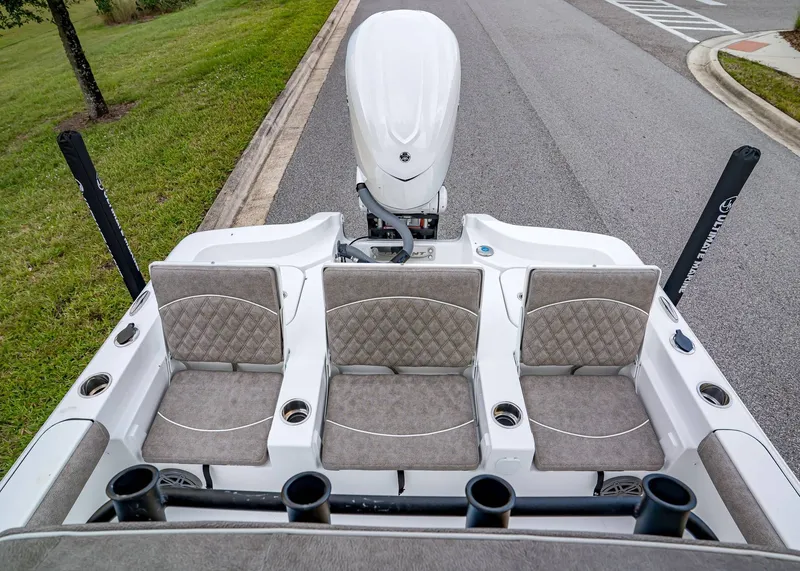 Slide: The Image of 2026 Sea Hunt BX 25 FS boat with cushioned seating and outboard motor on a road. - 8