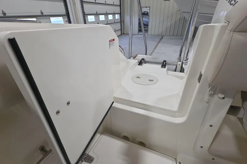 Slide: The Image of 2026 Boston Whaler 230 Outrage interior detail, showcasing storage and seating area. - 19