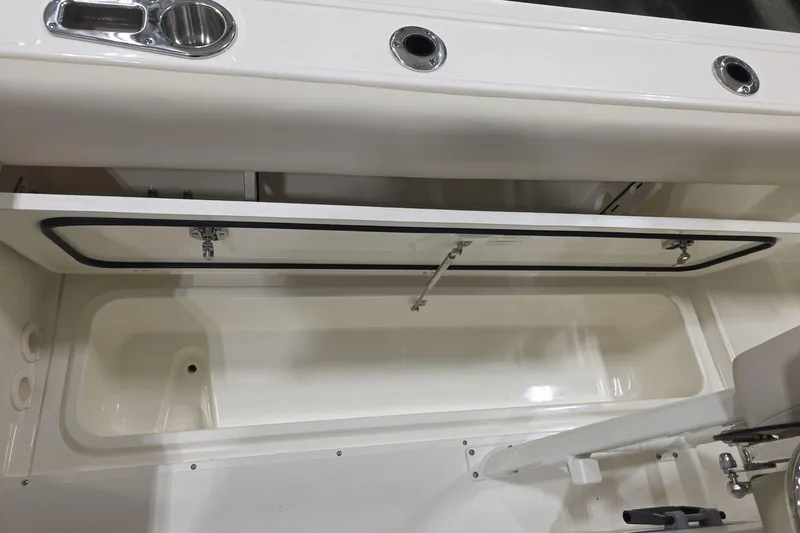 Slide: The Image of 2026 Boston Whaler 230 Outrage boat storage compartment with open hatch. - 21