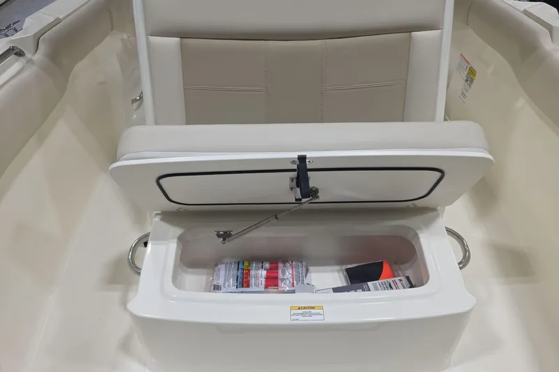 Slide: The Image of 2026 Boston Whaler 230 Outrage boat seat with storage compartment open. - 24