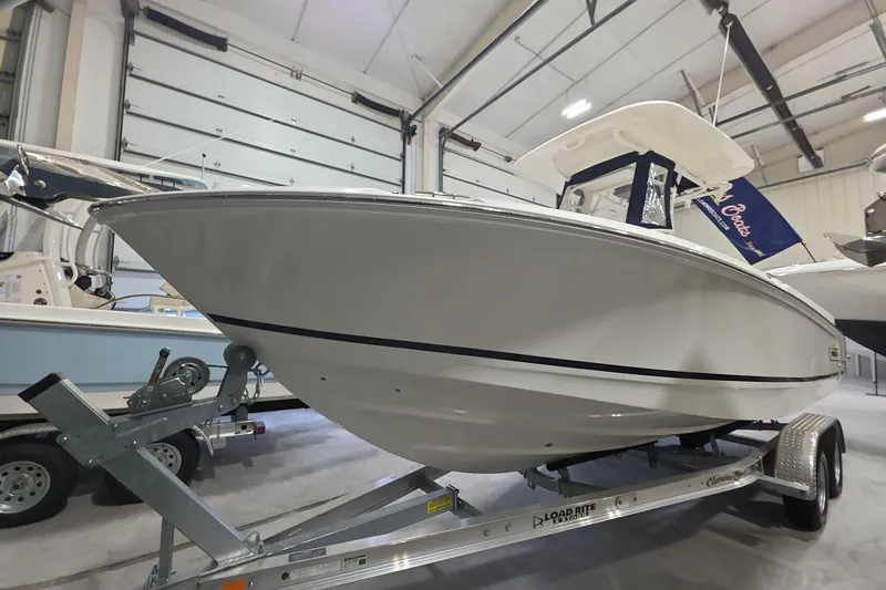 Slide: The Image of 2026 Boston Whaler 230 Outrage boat on trailer in indoor showroom. - 26