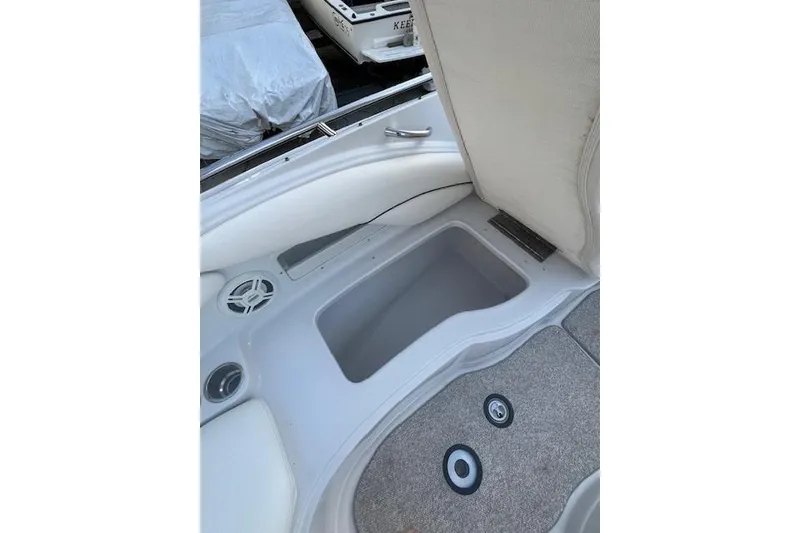 Slide: The Image of 2007 Crownline 320 LS boat interior storage compartment with speaker and carpeted flooring. - 22