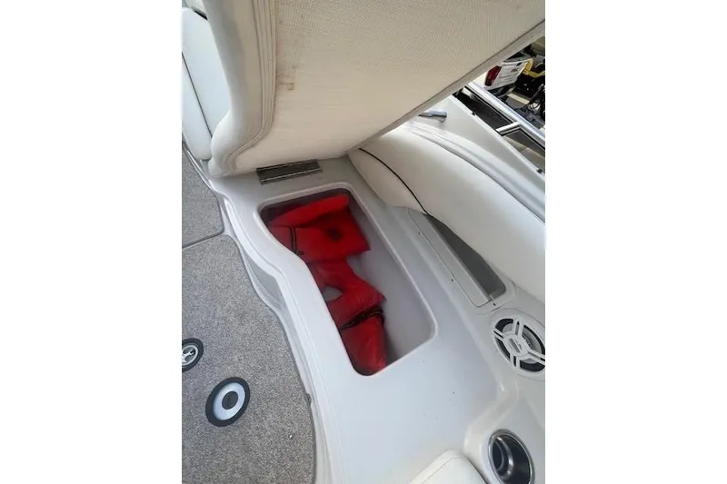 Slide: The Image of Storage compartment with red life jackets on a 2007 Crownline 320 LS boat. - 23