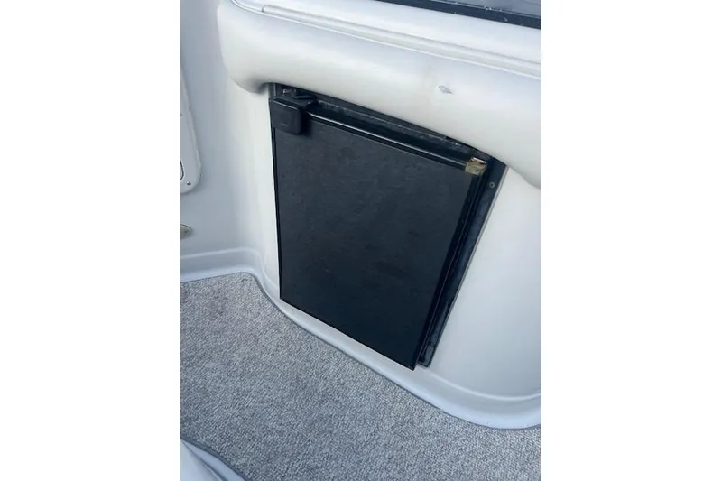Slide: The Image of 2007 Crownline 320 LS boat interior with compact black refrigerator. - 29