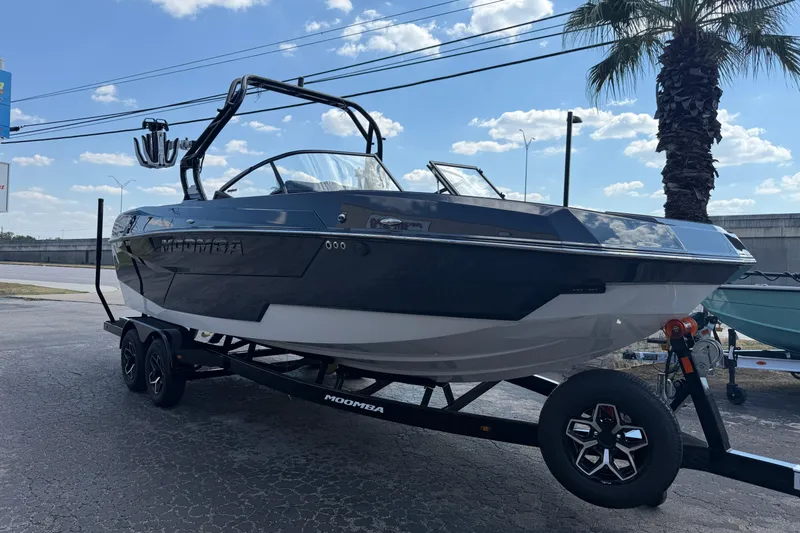 Slide: The Image of 2026 Moomba Tykon boat on trailer, parked outdoors under a sunny sky. - 3