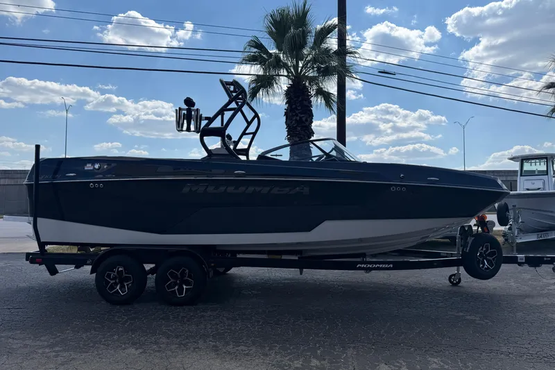 Slide: The Image of 2026 Moomba Tykon boat on trailer, parked outdoors under a blue sky. - 4