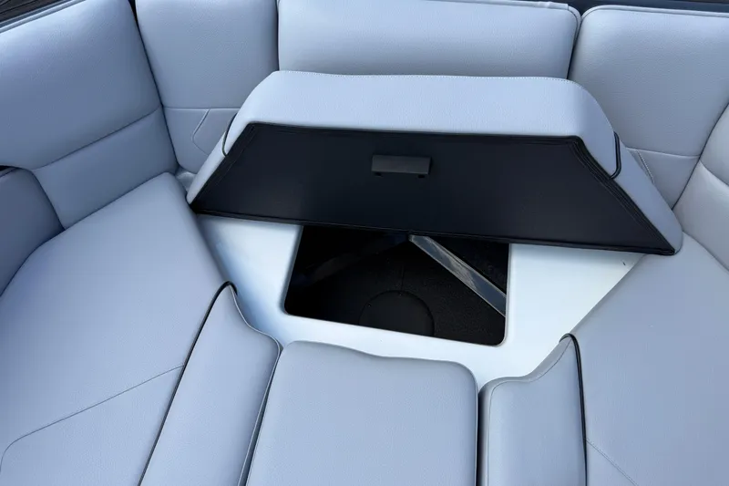 Slide: The Image of 2026 Moomba Tykon boat interior with open storage compartment and gray seating. - 46