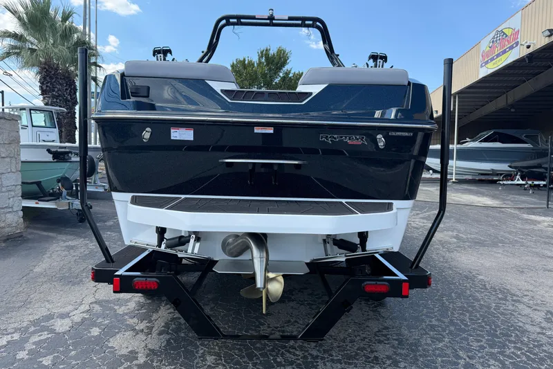 Slide: The Image of 2026 Moomba Tykon boat rear view, parked on a trailer in a marina. - 6