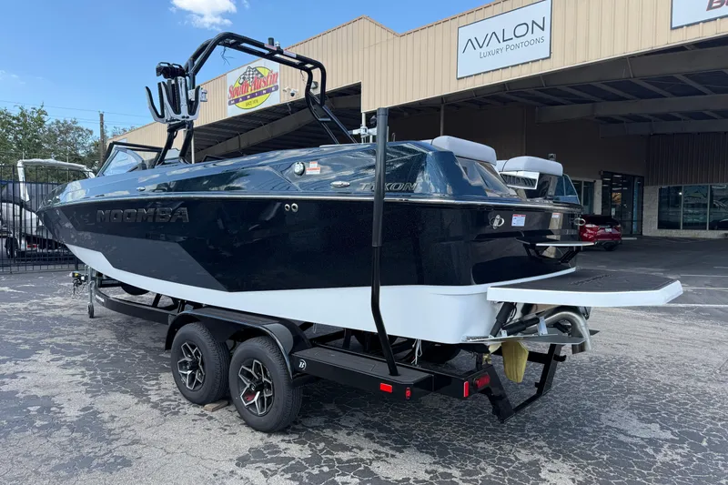 Slide: The Image of 2026 Moomba Tykon boat on trailer outside dealership, showcasing sleek design and modern features. - 9