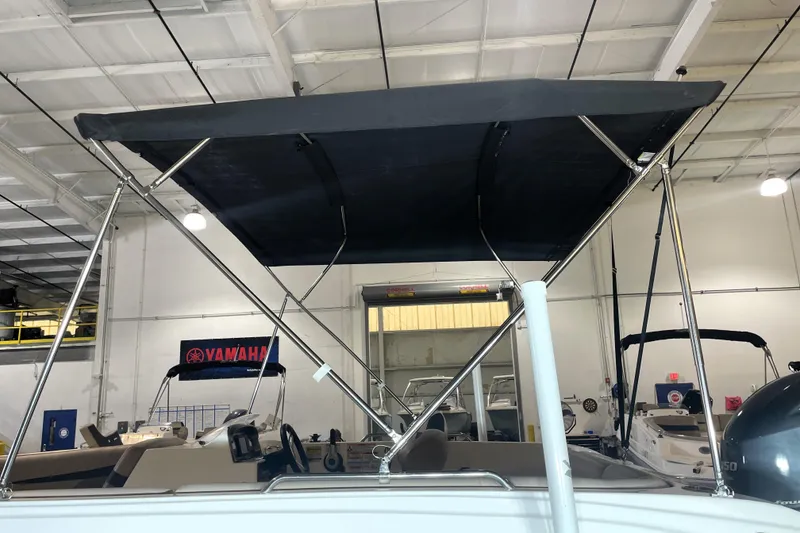 Slide: The Image of 2023 Hurricane SunDeck Sport 201 OB boat with bimini top in showroom. - 14