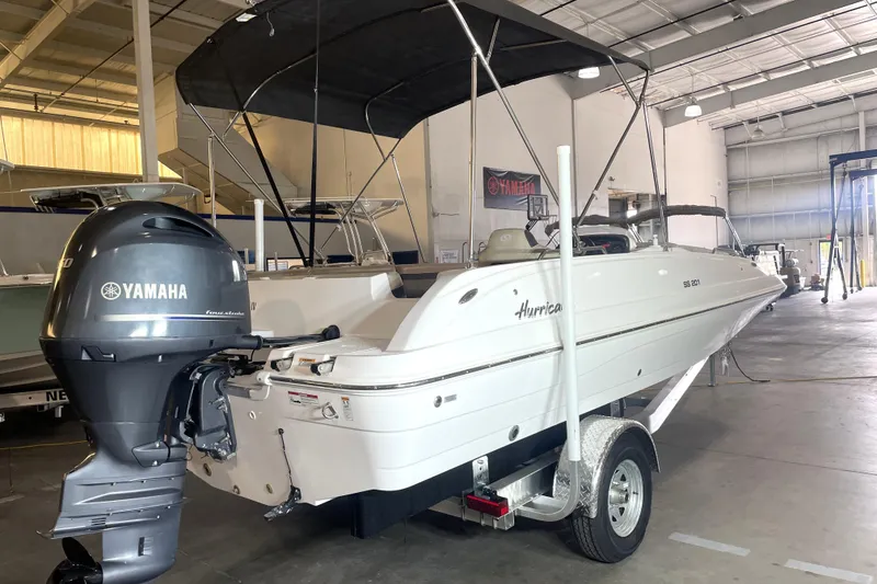 Slide: The Image of 2023 Hurricane SunDeck Sport 201 OB boat with Yamaha engine in a showroom. - 2