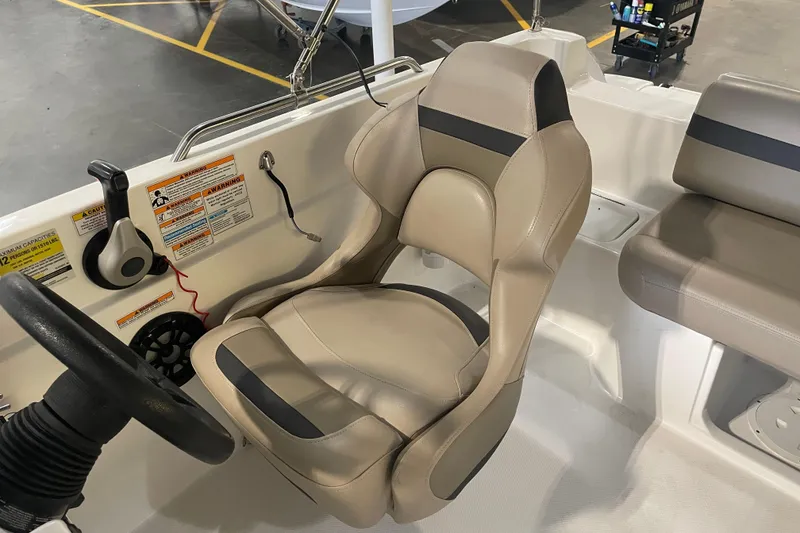 Slide: The Image of 2023 Hurricane SunDeck Sport 201 OB boat interior with beige captain's chair and steering wheel. - 22