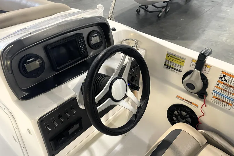 Slide: The Image of 2023 Hurricane SunDeck Sport 201 OB boat dashboard with steering wheel and controls. - 23