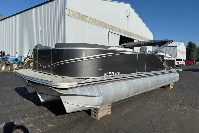 The Image of 2025 Avalon 2585 LSZ QL pontoon boat parked outside a large warehouse. - 0