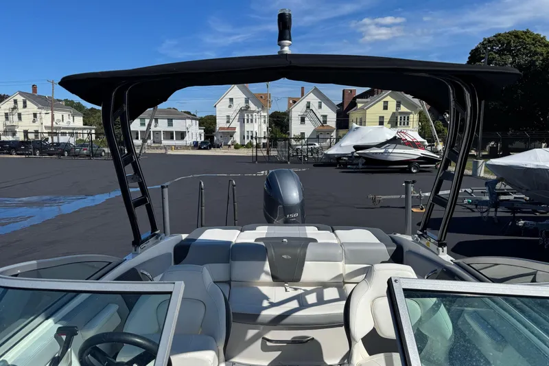 Slide: The Image of 2023 Chaparral 21 SSi OB boat with canopy, parked in a marina. - 4