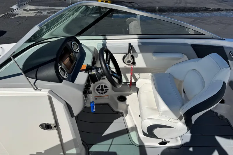 Slide: The Image of 2023 Chaparral 21 SSi OB boat interior with steering wheel and white seating. - 5