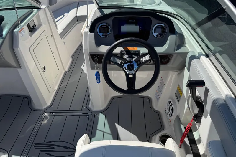 Slide: The Image of 2023 Chaparral 21 SSi OB boat interior with steering wheel and dashboard controls. - 6