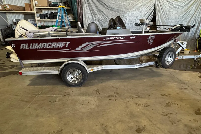 Slide: The Image of 2013 Alumacraft Competitor 165 Sport boat on trailer in a garage setting. - 0