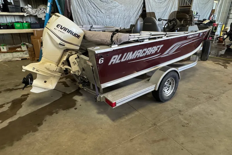 Slide: The Image of 2013 Alumacraft Competitor 165 Sport boat with Evinrude engine in a garage. - 3