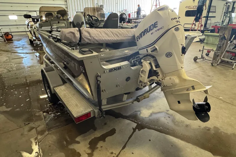 Slide: The Image of 2013 Alumacraft Competitor 165 Sport boat with Evinrude motor in a garage setting. - 4