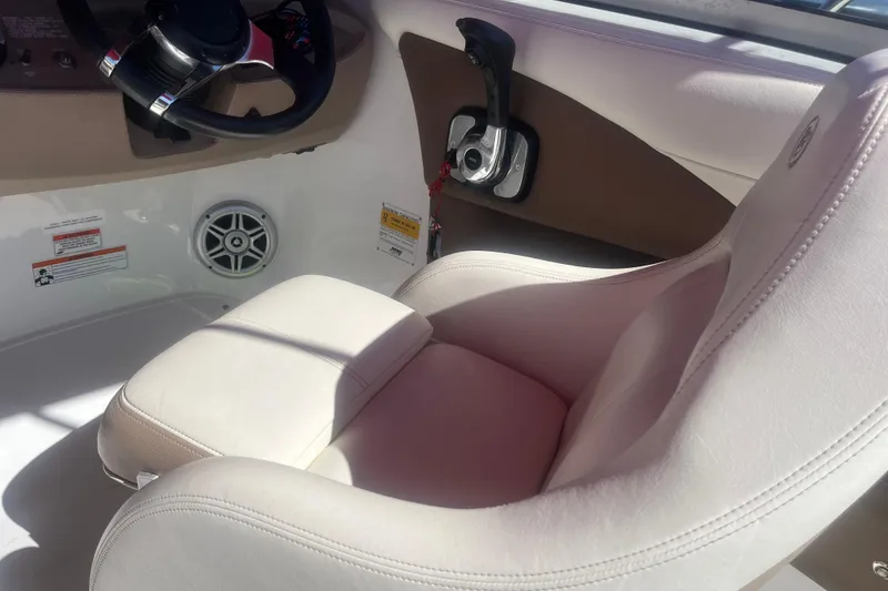 Slide: The Image of Interior of a 2011 Cobalt 210 boat featuring a white captain's seat and control panel. - 10