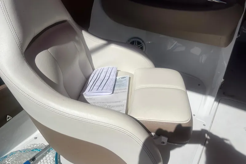 Slide: The Image of White leather seat in a 2011 Cobalt 210 boat with documents placed on it. - 9