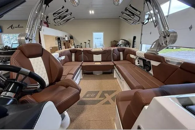 Slide: The Image of 2023 MasterCraft XT23 boat interior with luxurious brown seating and modern design. - 3