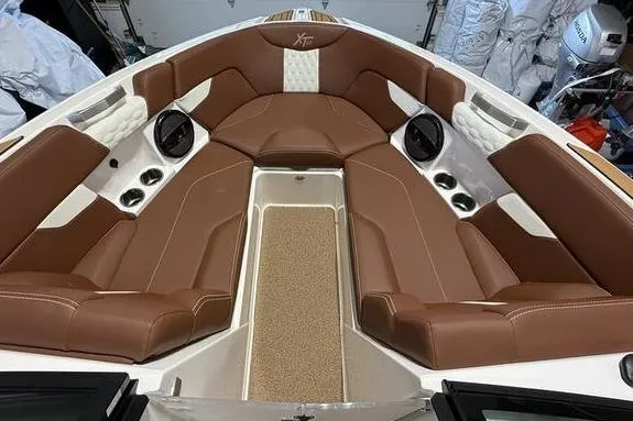 Slide: The Image of 2023 MasterCraft XT23 boat interior with brown leather seating and modern design. - 6