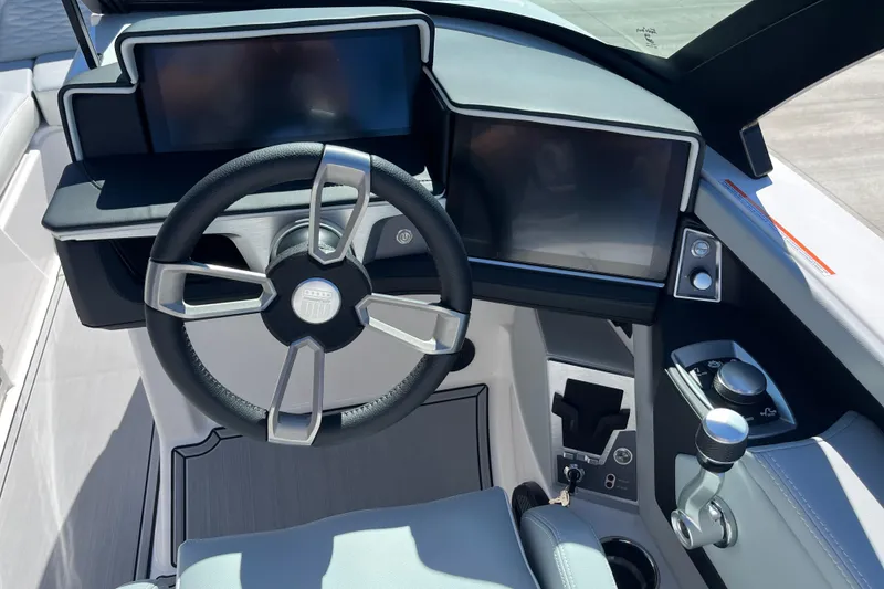 Slide: The Image of 2025 MasterCraft X22 boat dashboard with modern steering wheel and digital displays. - 11