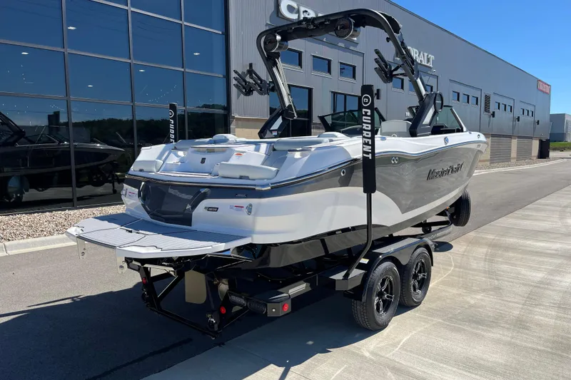 Slide: The Image of 2025 MasterCraft X22 boat on trailer outside dealership, showcasing sleek design and modern features. - 4